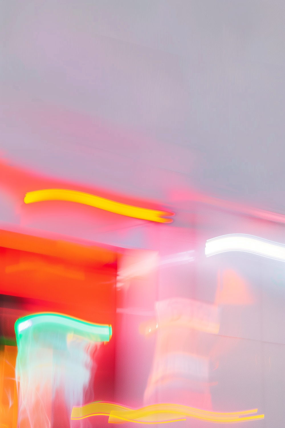 Streaks of red, yellow and green neon light against a dark background